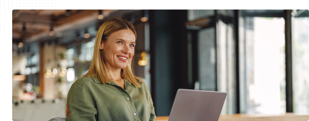 Femme souriante travaillant sur un ordinateur portable, illustrant la formation à distance au métier de secrétaire dentaire.