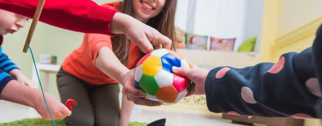 des mains d'enfants qui attrapent une balle molle 