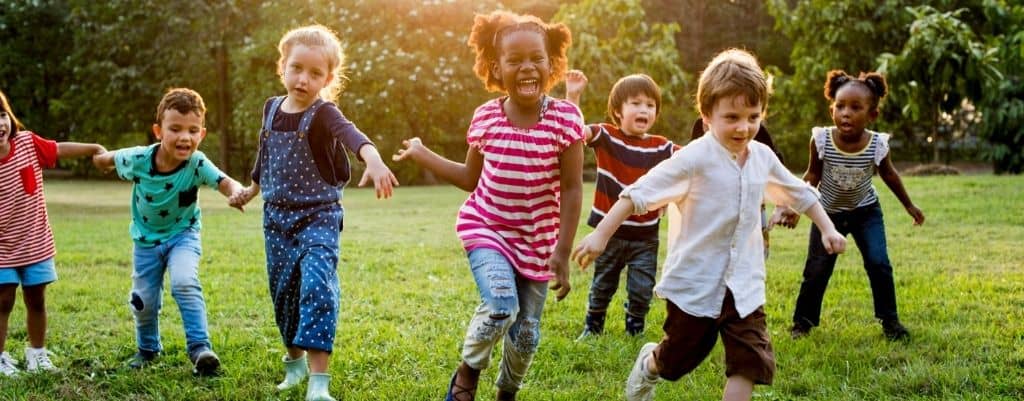 des enfants heureux qui jouent dans l'herbe