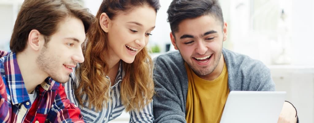 trois étudiants qui regardent un ordinateur