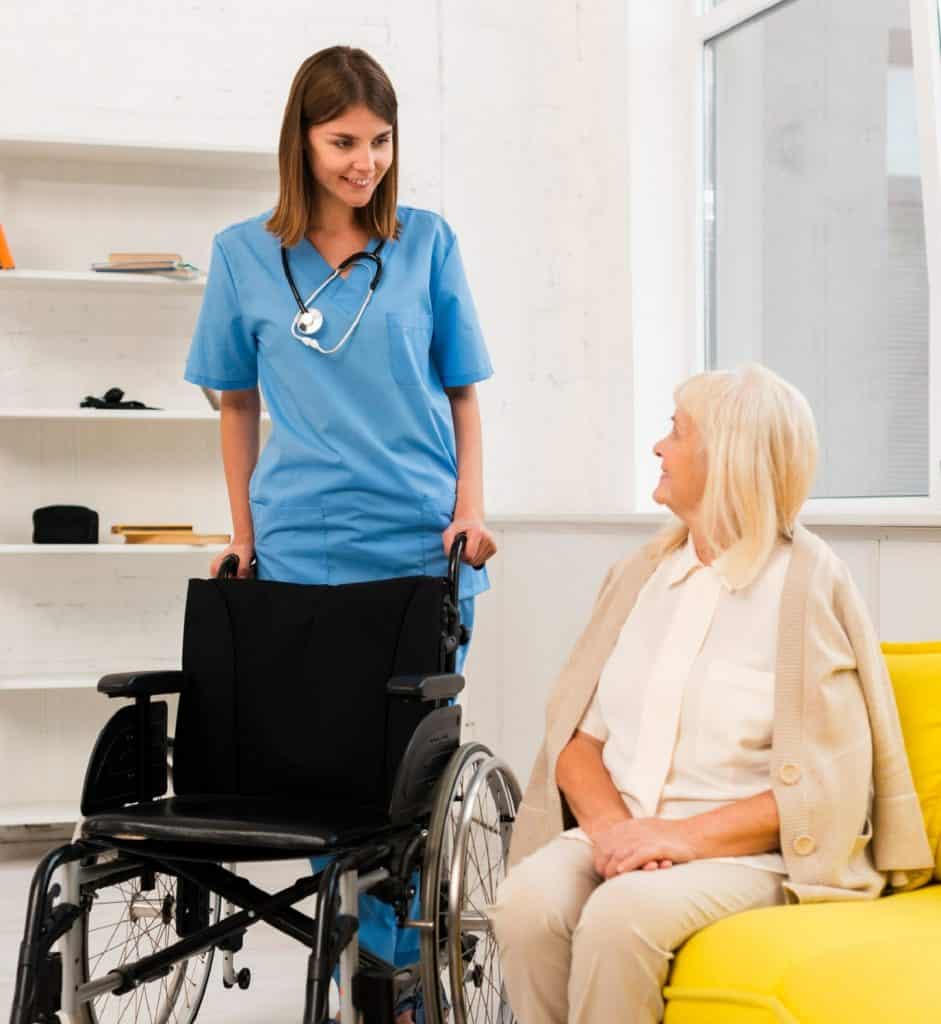 soignante tenant un fauteuil roulant