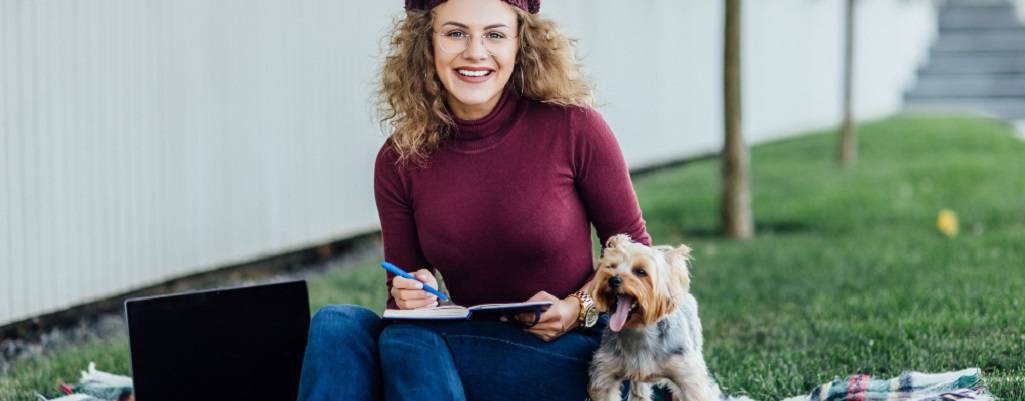 femme avec son chien assis sur l'herbe