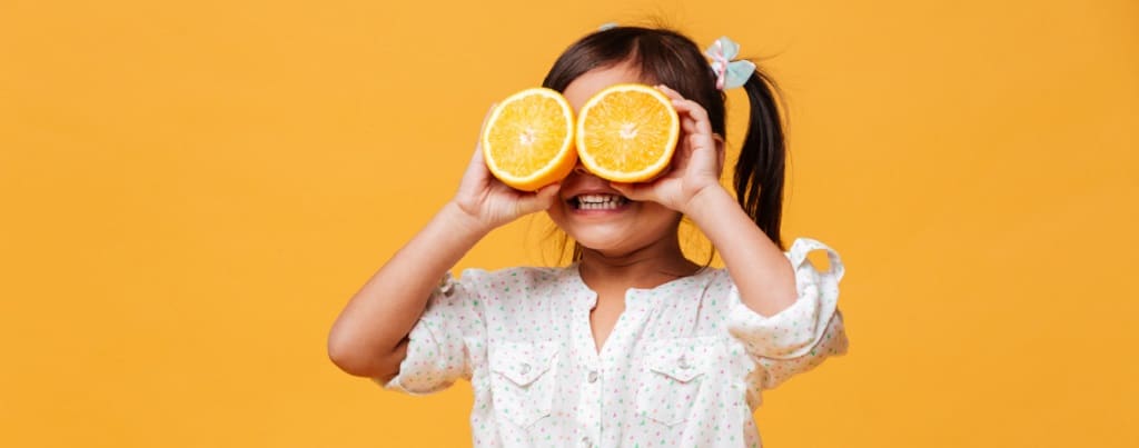 petite fille avec des oranges sur les yeux