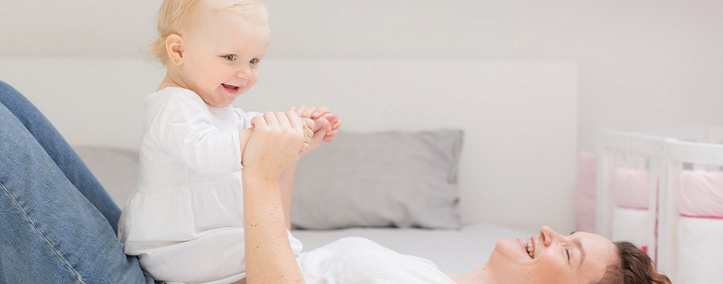 un bébé joue sur sa maman