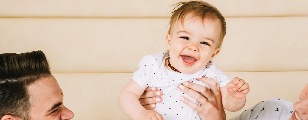 bébé fait un sourire à ses parents