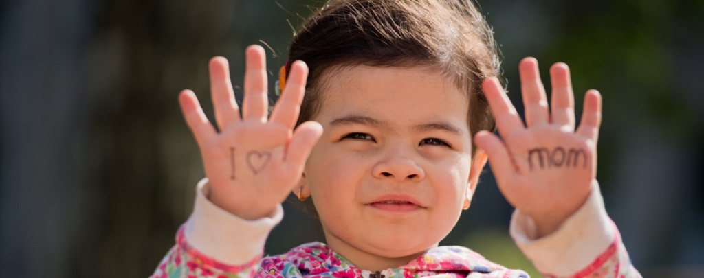 un enfant faisant des signes avec ses mains
