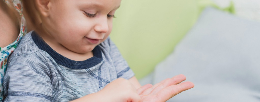 un enfant touchant la main de sa maman