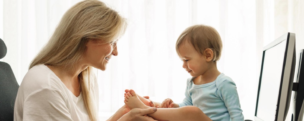 une maman tenant les pieds de son bébé