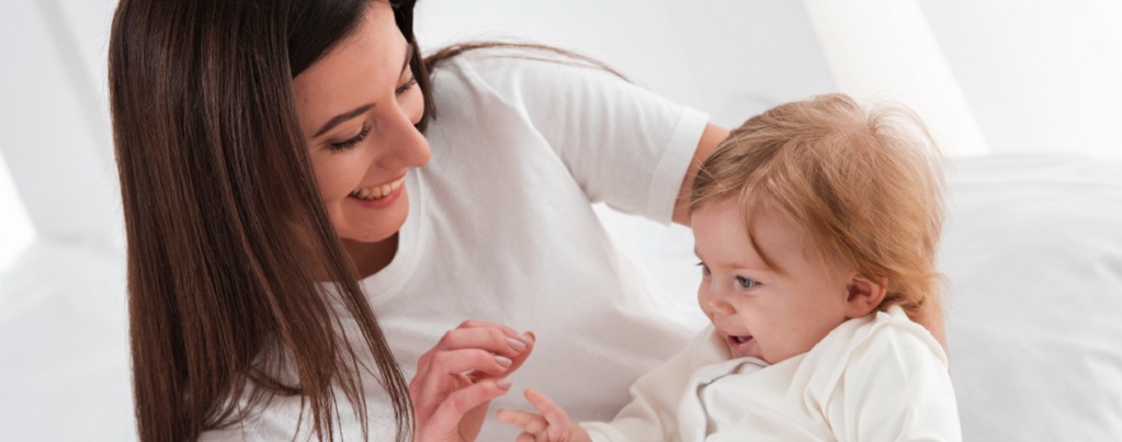 une maman faisant un signe à son bébé