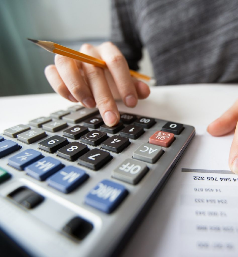 un homme calculant son salaire avec une calculatrice