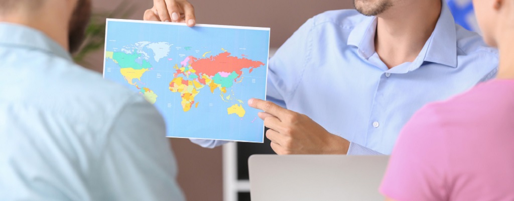 un homme montrant une carte du monde