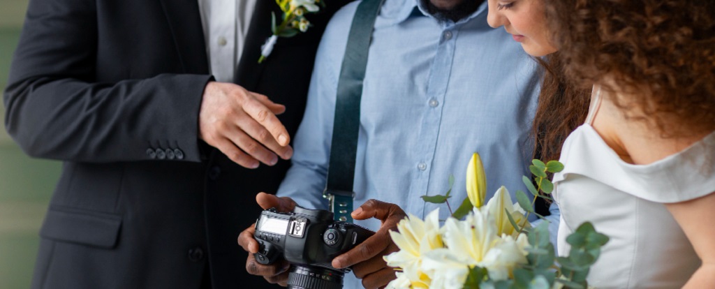un photographe montrant les photos à des mariés