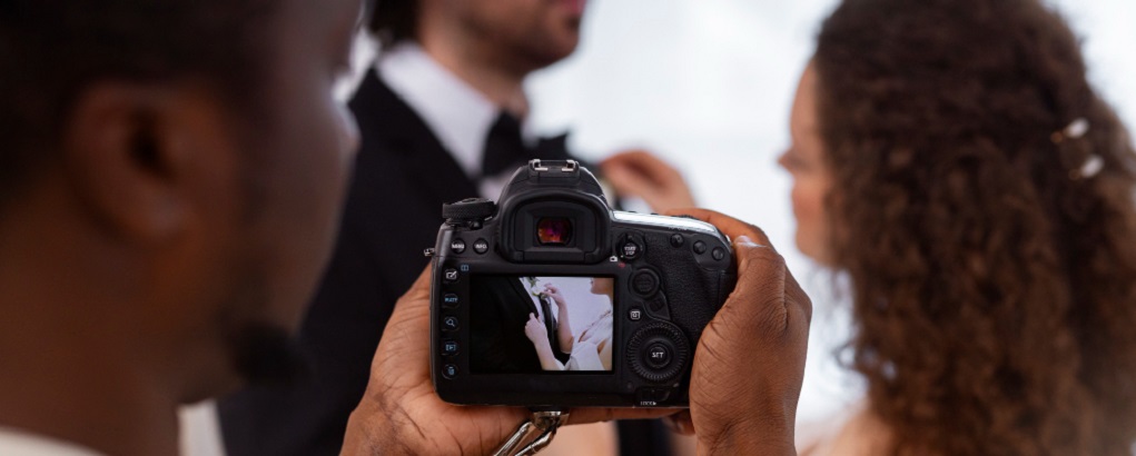 un photographe prenant un cliché d'un couple se préparant pour un évènement de famille