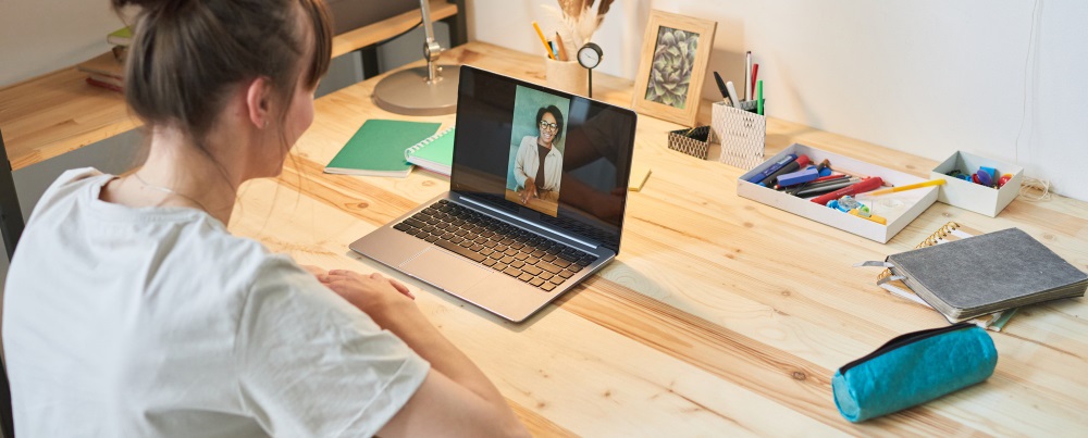 une femme suivant un cours à distance sur son bureau