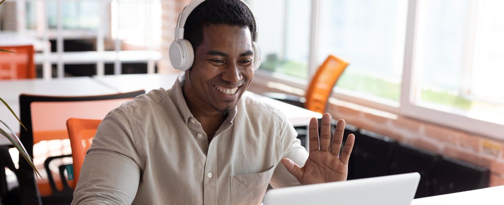 un homme souriant devant son ordinateur portable