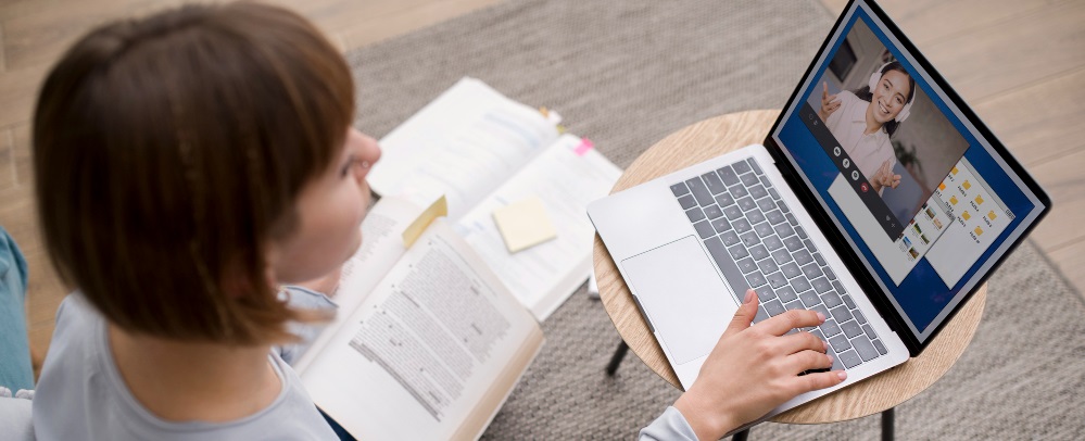 une femme suivant une formation en ligne devant son ordinateur portable