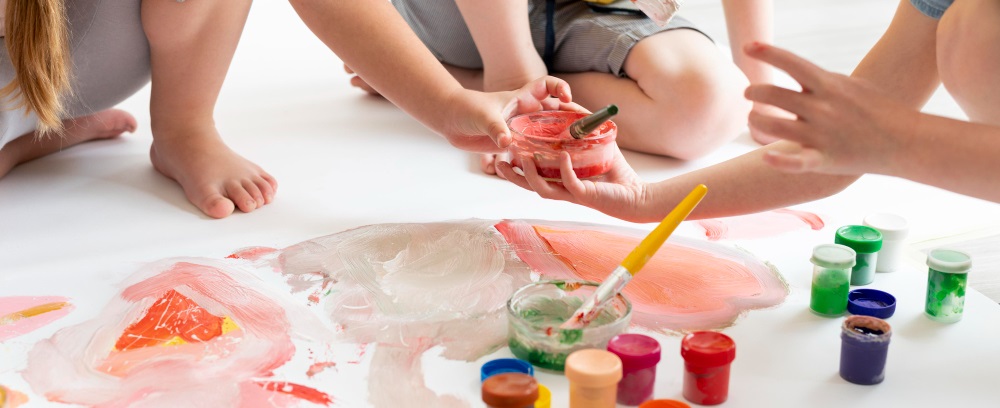 des enfants faisant de la peinture au sol