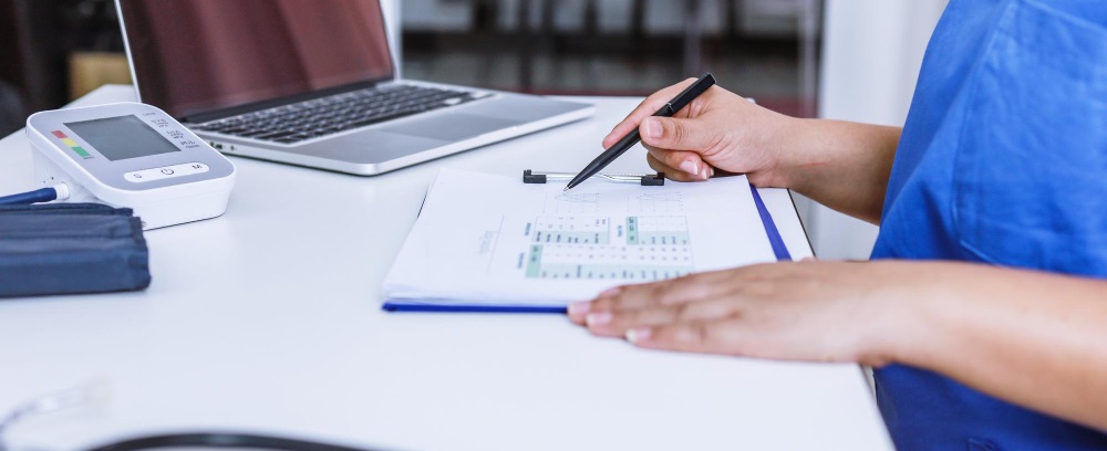 une personne du paramédical travaillant sur son bureau