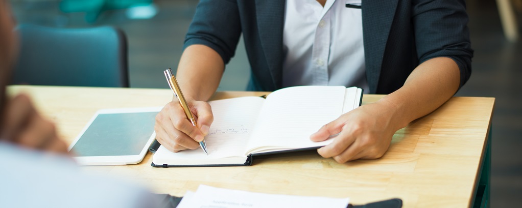 une personne écrivant sur un cahier