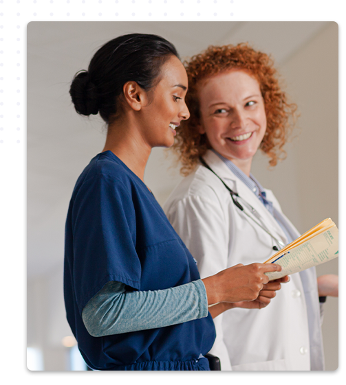 Deux professionnelles de santé en conversation, une secrétaire médicale tenant des papiers et une médecin en blouse blanche avec un stéthoscope, toutes deux souriantes et engagées dans une discussion.