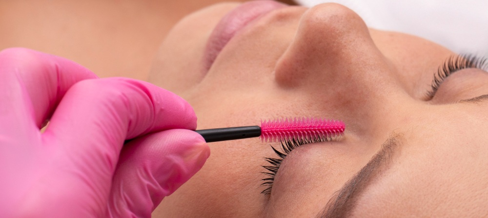 une femme se faisant teindre les cils chez un professionnel