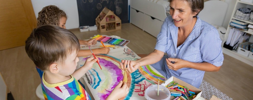 une auxiliaire petite enfance jouant avec un enfant