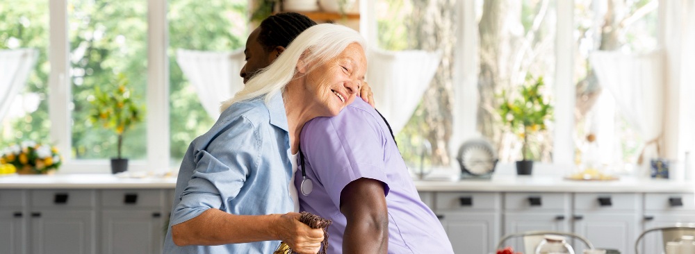 une auxiliaire de vie faisant un calin à une personne