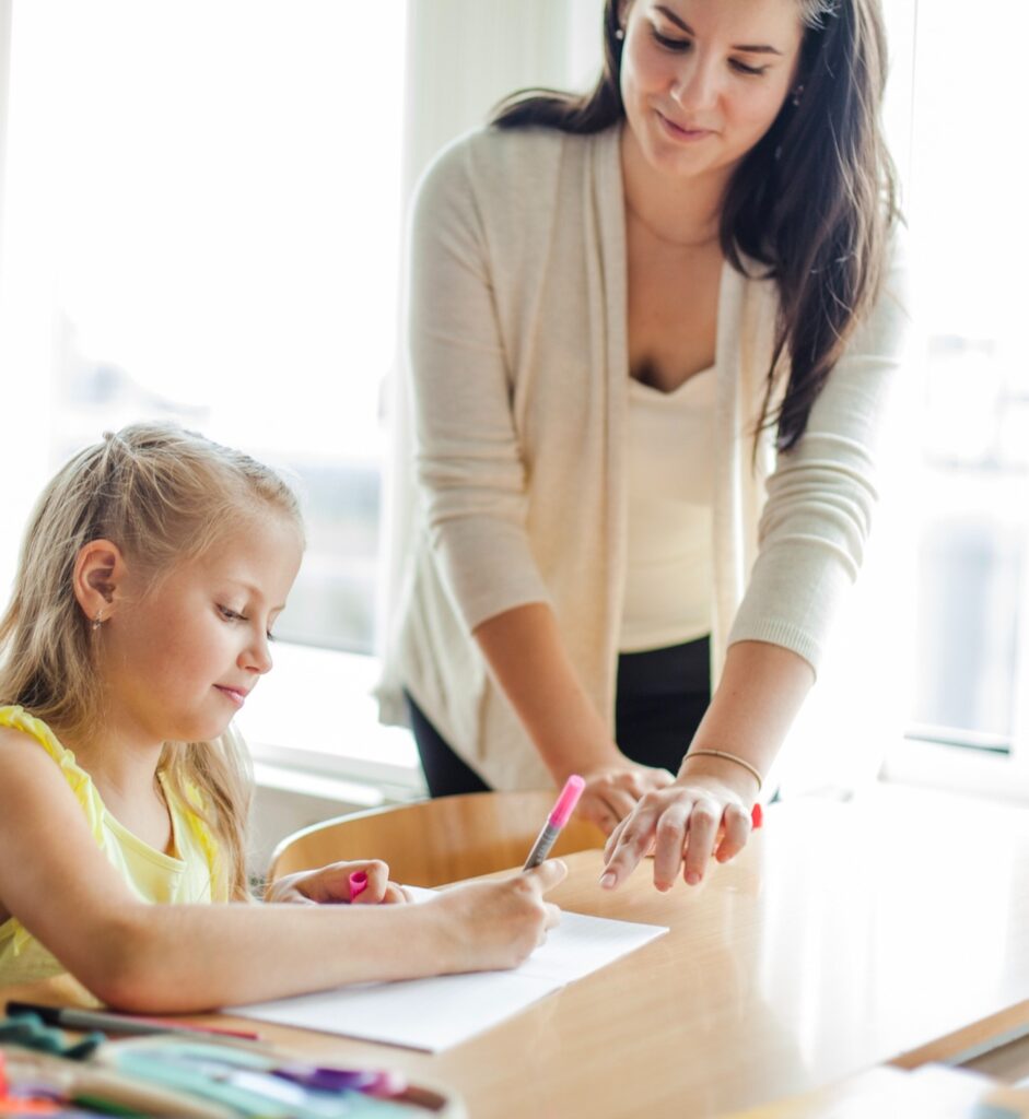 Une ATSEM avec un enfant travaillant