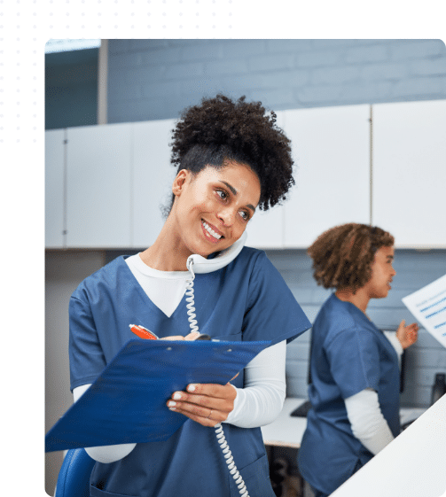 Femme souriante étudiant à distance depuis sa cuisine, carnet et ordinateur devant elle