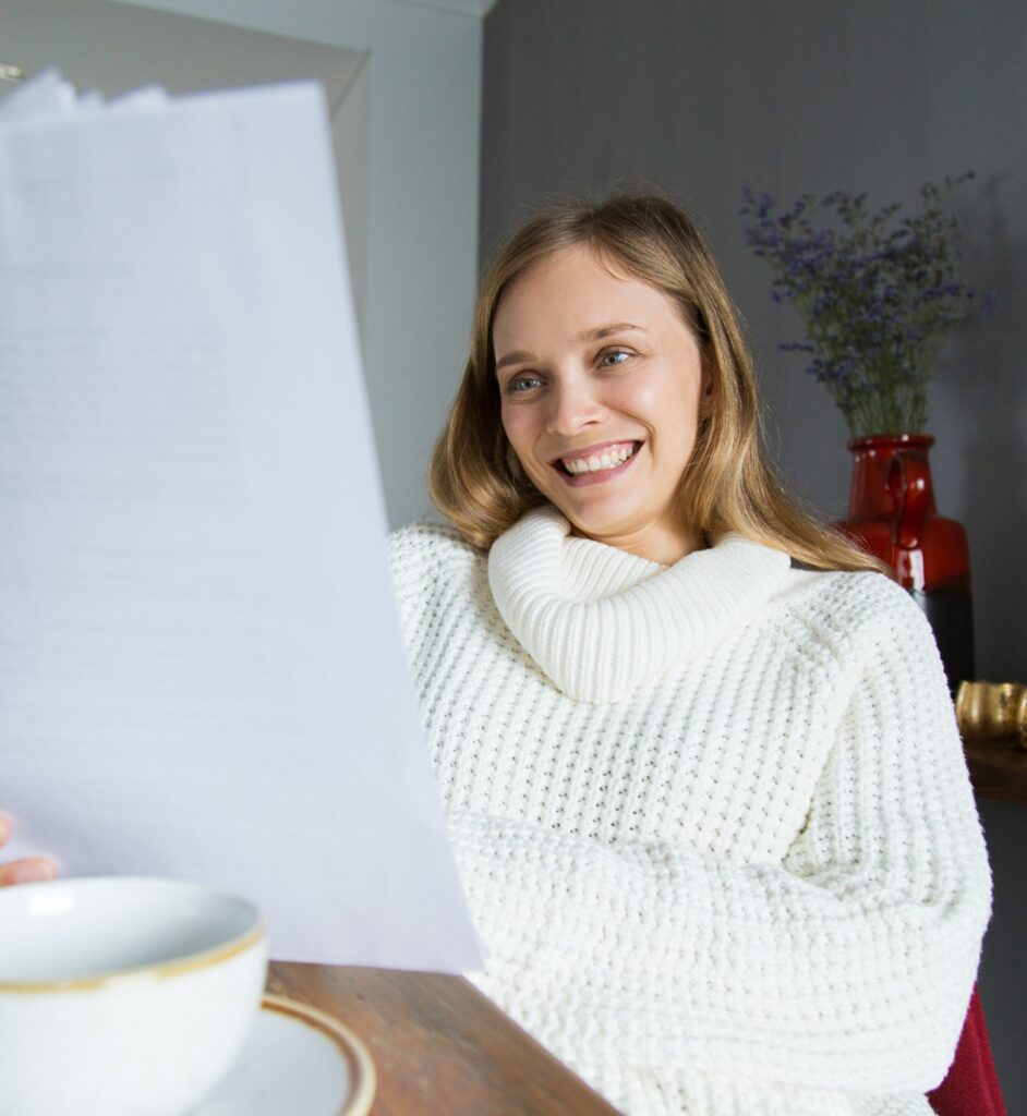 Une personne souriante lisant sa lettre de motivation