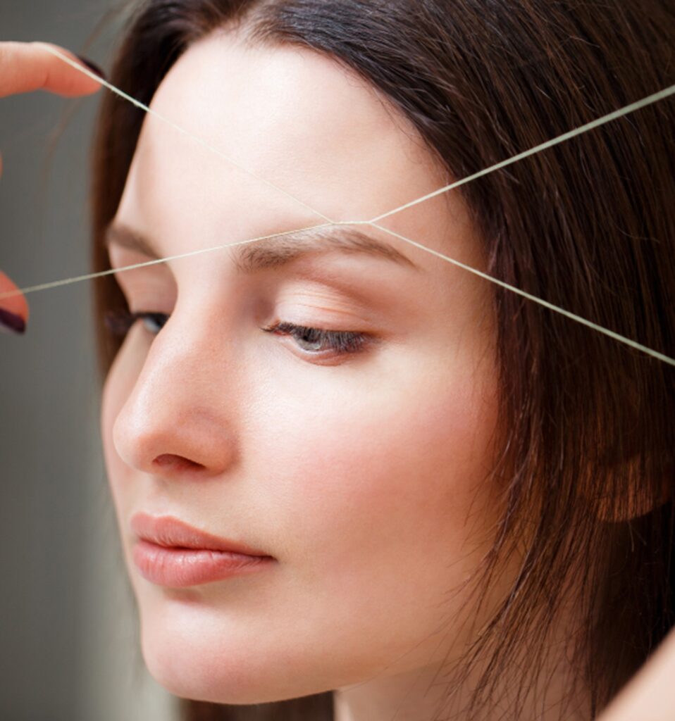 une femme en pleine séance d'épilation au fil