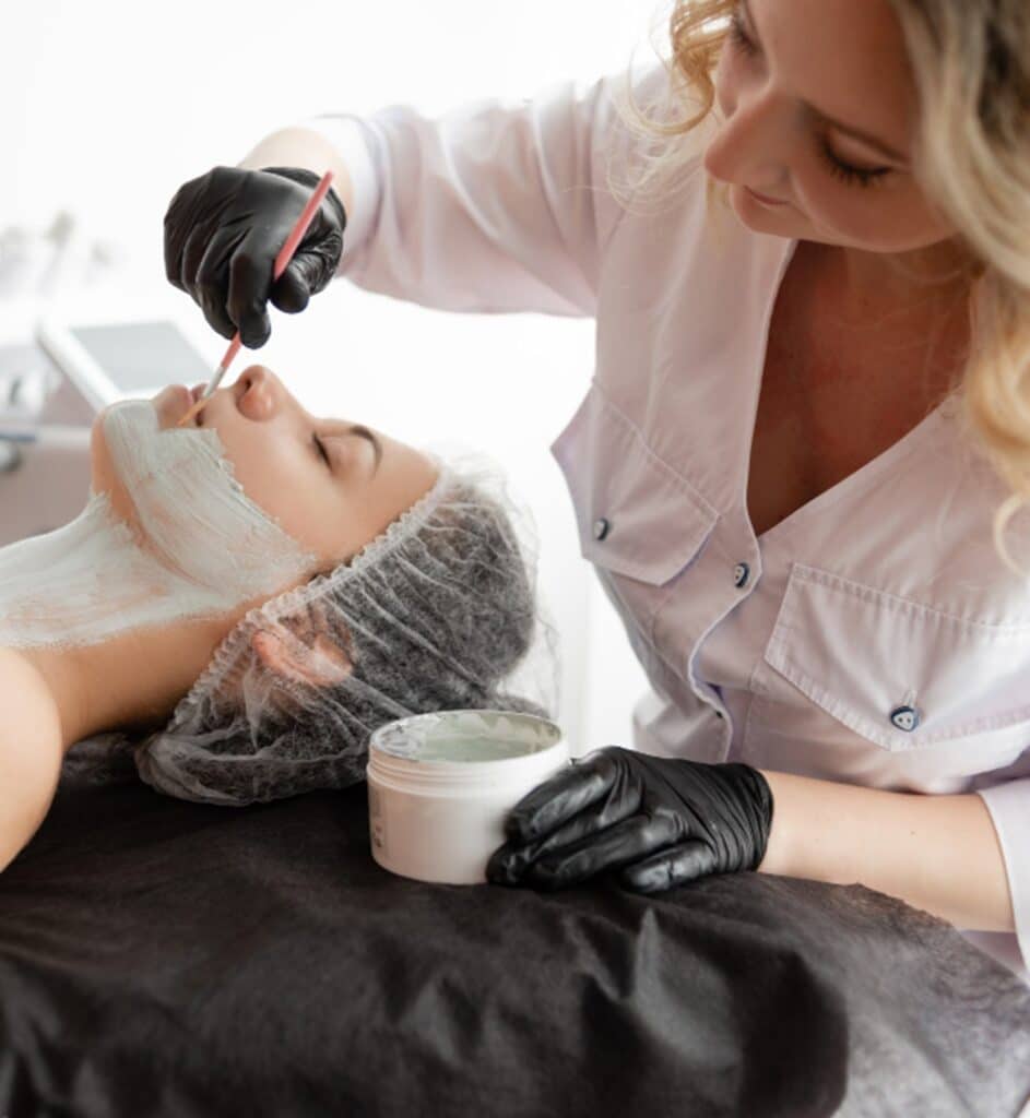 une esthéticienne faisant un masque à une cliente